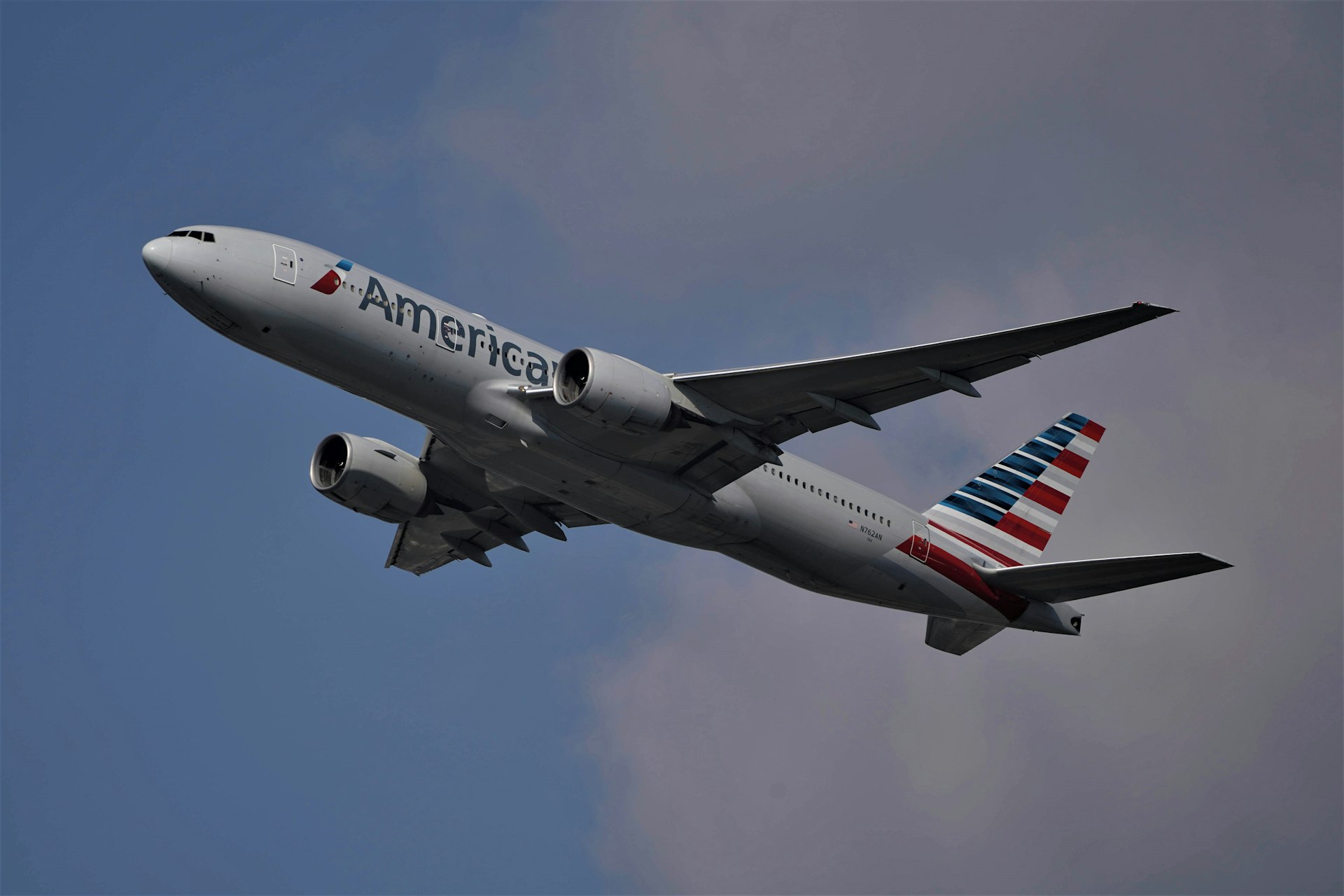 white and red passenger plane flying in the sky during daytime